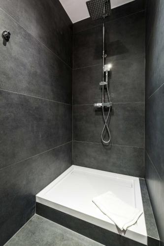 a bathroom with a shower with a white bath tub at Sopot Pier Apartments by OneApartments in Sopot
