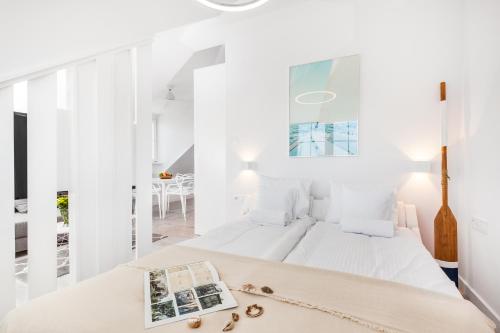a white bedroom with a bed and a mirror at Sopot Pier Apartments by OneApartments in Sopot