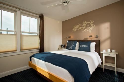 a bedroom with a large bed with blue pillows at Benchmark Inn in Provincetown