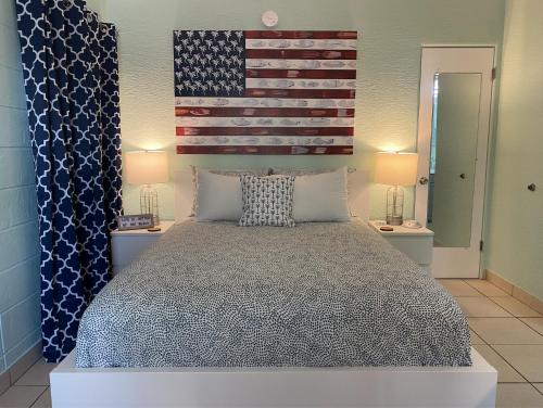 a bedroom with a bed with an american flag on the wall at The Beach House - Treasure Island in St Pete Beach