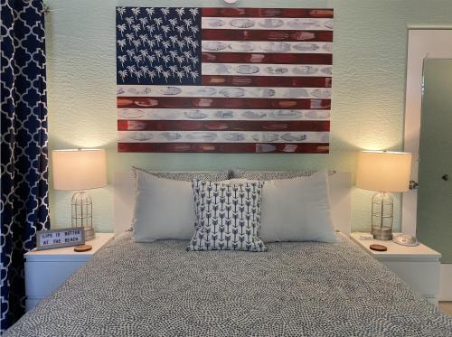 a bed with an american flag on the wall at The Beach House - Treasure Island in St Pete Beach