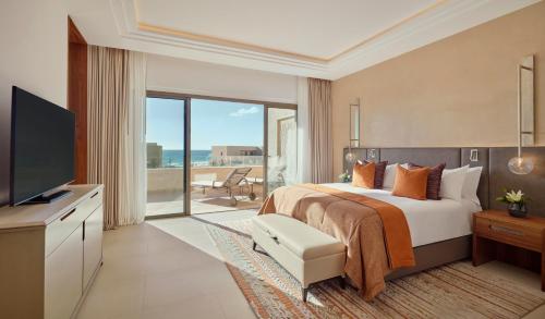 a hotel room with a bed and a television at Fairmont Taghazout Bay in Taghazout