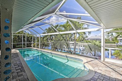 an indoor swimming pool with a large glass wall at Canal Waterfront Home with Private Pool and Dock! in Punta Gorda