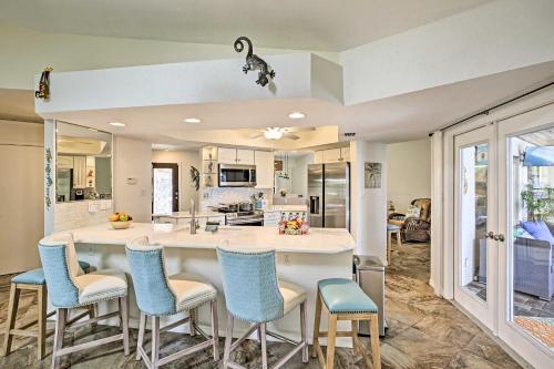 a kitchen with a large island with blue chairs at Canal Waterfront Home with Private Pool and Dock! in Punta Gorda