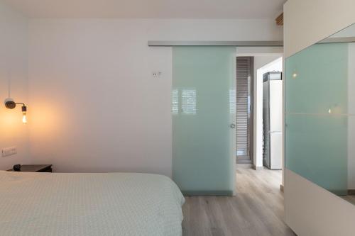 una camera con letto e parete in vetro di Tropical Lodge a Maspalomas