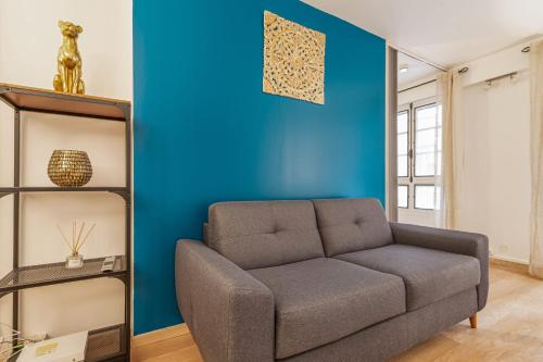 uma sala de estar com um sofá e uma parede azul em Modern flat 50m from the Capitole - Toulouse - Welkeys em Toulouse