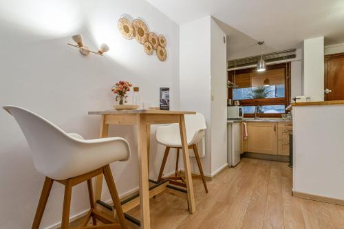 uma cozinha com uma mesa e duas cadeiras brancas em Modern flat 50m from the Capitole - Toulouse - Welkeys em Toulouse