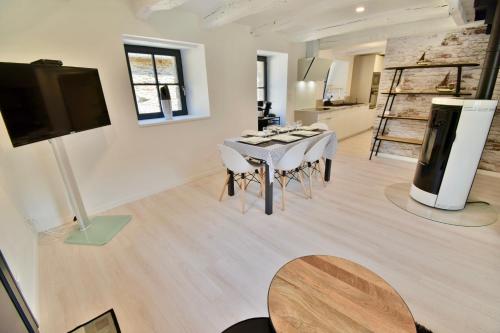 un salon avec une table, des chaises et une télévision dans l'établissement Domaine Bella Laïta - Gîtes et Chambres D'hôtes, à Clohars-Carnoët