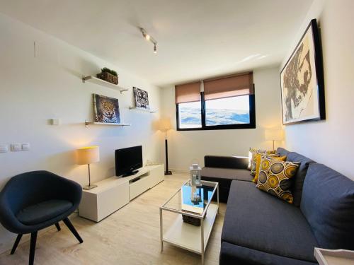 sala de estar con sofá y TV en Apartamentos Bluettravel Snow Confort Monte Gorbea, en Sierra Nevada