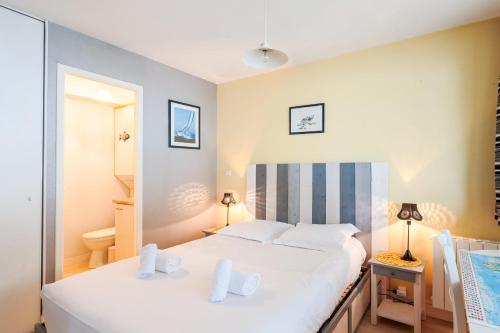 - une chambre avec un grand lit et des draps blancs dans l'établissement Appartement Passereaux - Welkeys, à La Rochelle