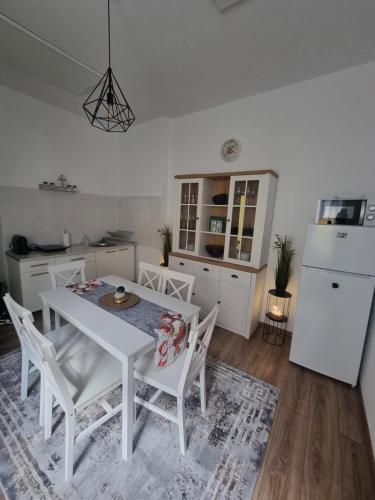 cocina con mesa blanca, sillas y nevera en Celebrity Apartment Brasov, en Brasov