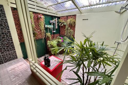 a cat sitting on a red bench in a room with plants at Baan Bua Cottage SHA EXTRA PLUS B5510 in Ko Kood