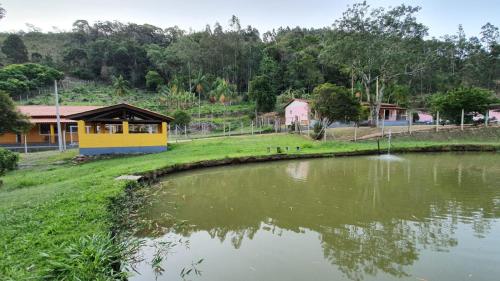 un petit étang en face d'un bâtiment dans l'établissement Chacara Ceara, à Monte Alegre do Sul