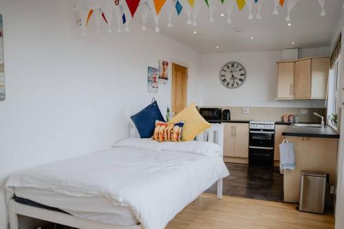 a bedroom with a bed and a kitchen with a clock at The Nook in Barnstaple