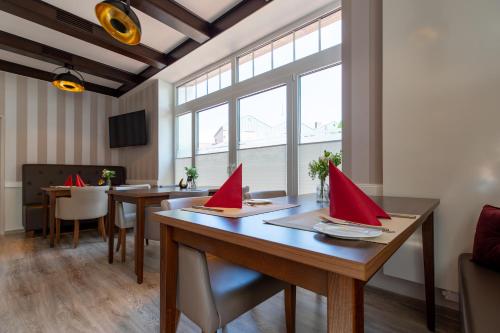 a dining room with red napkins on a wooden table at Hotel Steyerberger Hof in Steyerberg