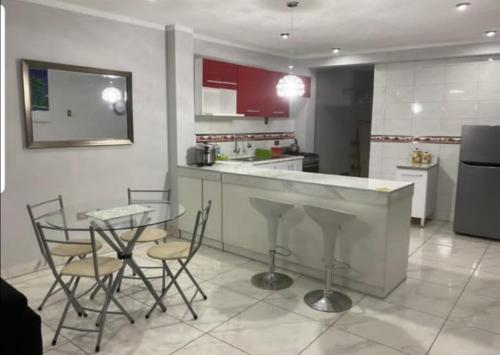 cocina con encimera, mesa y sillas en Barranca Beach Apartments, en Barranca