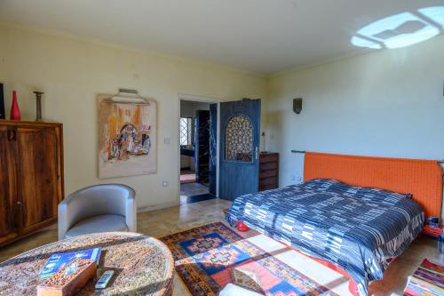 a bedroom with a bed and a table and chairs at Prestige du Souss in Oulad Berhil