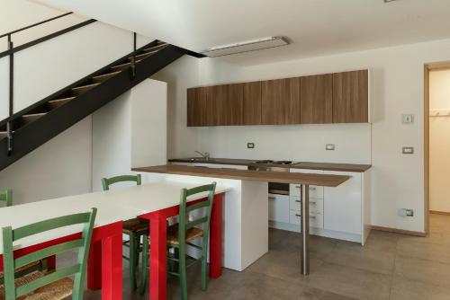 a kitchen with a table and chairs and a staircase at Fioralpino Suites in Sospirolo
