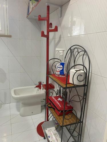 a bathroom with a toilet and a shelf with toiletries at Villa Ulivi in Tocco da Casauria