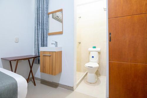 a bathroom with a toilet and a sink at Ayenda Juglar in Valledupar