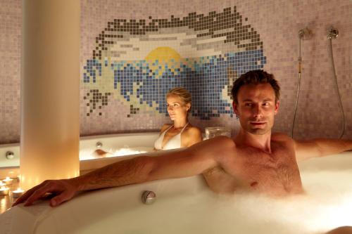 a man and a woman in a bath tub at Hotel Zum Löwen - Al Leone in Meltina