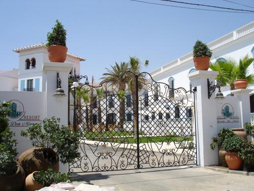 a gate in front of a white house with plants at Hotel Hacienda Don Manuel in Granja de Torrehermosa