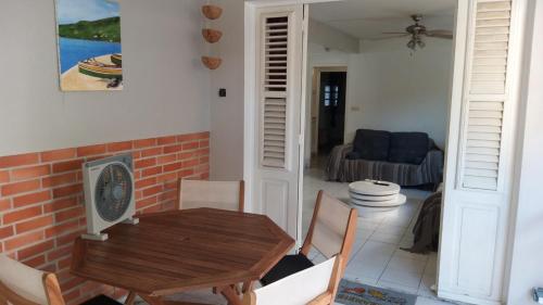 a living room with a wooden table and chairs at Grand F2, spa, jardin, parking in Schœlcher