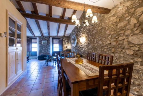 a kitchen with a stone wall and a table and chairs at Can Llobet in Capmany