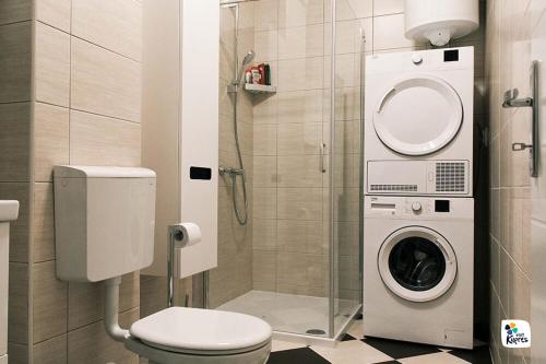 a bathroom with a toilet and a washing machine at Apartman Anđela in Kupres