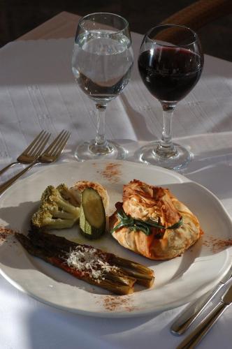 a plate of food on a table with glasses of wine at Frontzu Politia in Ioannina