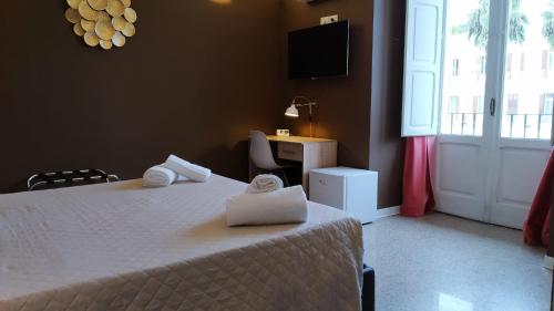 a bedroom with a bed and a desk and a window at CconfortHotels R&B Central Rooms in Bari