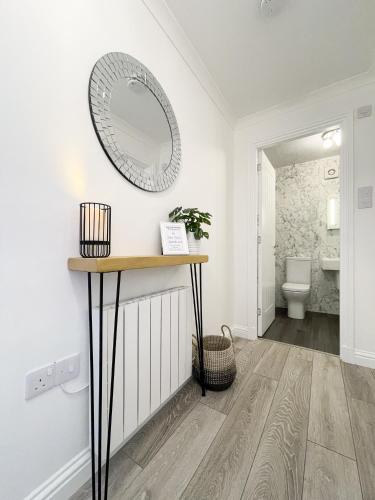 a bathroom with a mirror on the wall at Pier View Apartment in Oban