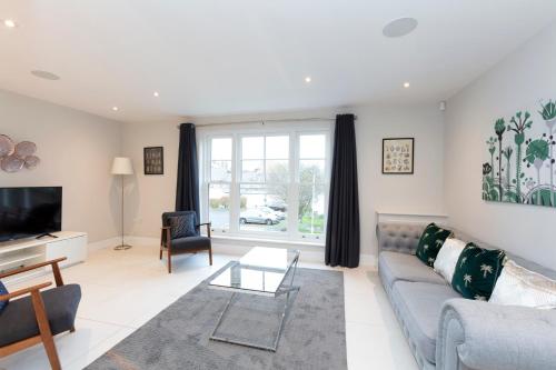 a living room with a couch and a tv at Stunning Central Windsor Town House With Parking in Windsor