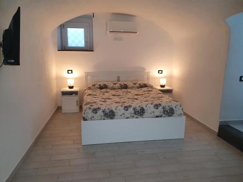 um quarto com uma cama e duas mesas de cabeceira em MASSERIA ALWAYS em Boscoreale
