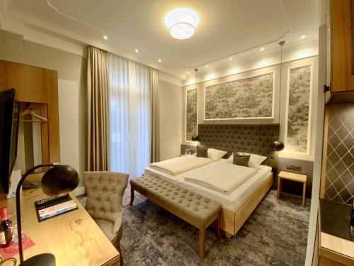 a bedroom with a large bed and a desk at Hotel West an der Bockenheimer Warte in Frankfurt/Main