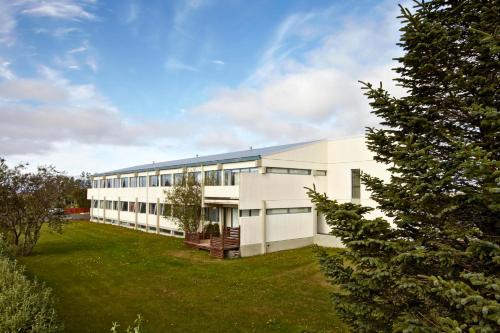 um grande edifício branco com um pátio verde em Hotel Jökull em Höfn