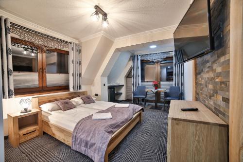 a bedroom with a bed and a flat screen tv at Willa Śwarna II in Zakopane