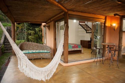 a hammock in a room with a bedroom at Pousada Ecológica Espelho D'Água in Carrancas