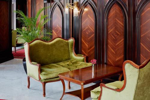 a living room with a couch and a table and chairs at Hotel Atlas Deluxe in Lviv