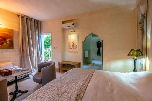 a bedroom with a bed and a chair and a table at Prestige du Souss in Oulad Berhil