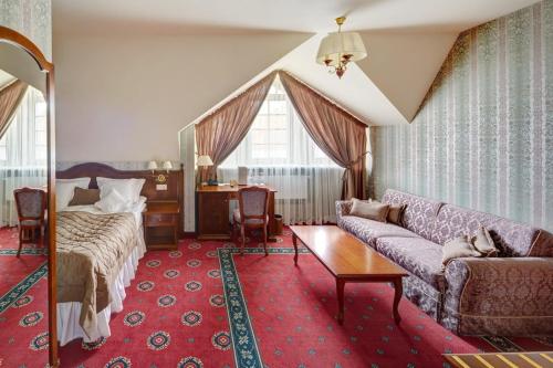 a living room with a couch and a bed at Hotel Atlas Deluxe in Lviv
