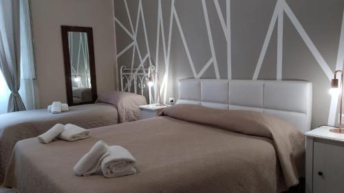 1 dormitorio con 2 camas y toallas. en CconfortHotels R&B Dolci Notti - SELF CHECK IN, en Bari