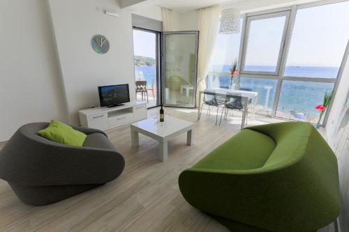 a living room with two green chairs and a table at Apart Hotel Sea Fort in Sutomore