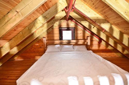 a bed in a wooden room with a attic at Yagorov Chalet in Yavneʼel