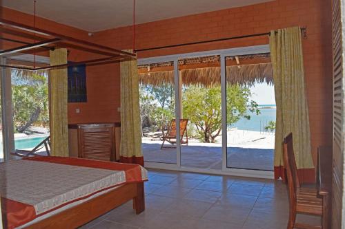 a bedroom with a bed and a view of the beach at Antsanitia - Domaine du Mandravasarotra in Antsianitia