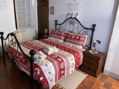 蒙特普齊亞諾的住宿－La casina in Via Fiorita，一间卧室配有一张带红色和白色棉被的床