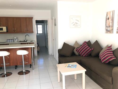 a living room and kitchen with a couch and a table at Casa M's One bedroom apartment with communal pool in Matagorda in Puerto del Carmen