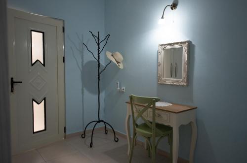 a blue room with a desk and a lamp and a chair at Arhondia House in Ierápetra