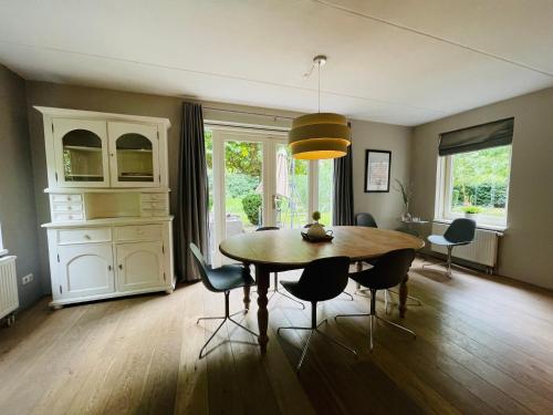 a dining room with a table and chairs at VILLA CALMA Rust Ruimte Luxe inclusief private jacuzzi in Zeewolde