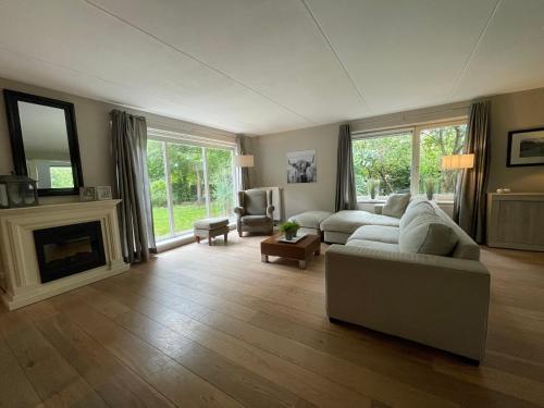 a living room with a couch and a fireplace at VILLA CALMA Rust Ruimte Luxe inclusief private jacuzzi in Zeewolde